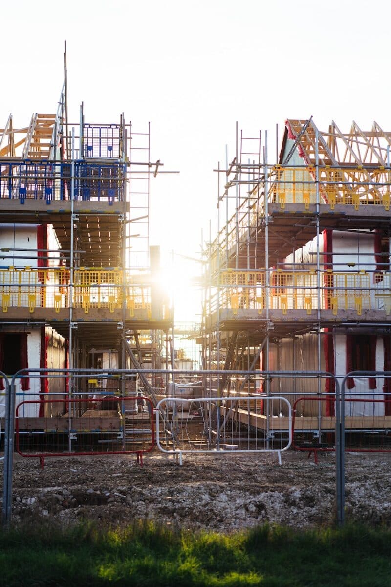 Construction of new homes with scaffolding and sun.