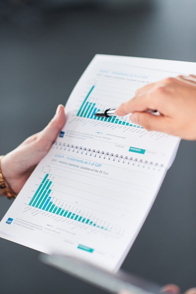 Hands pointing at data charts in a document.