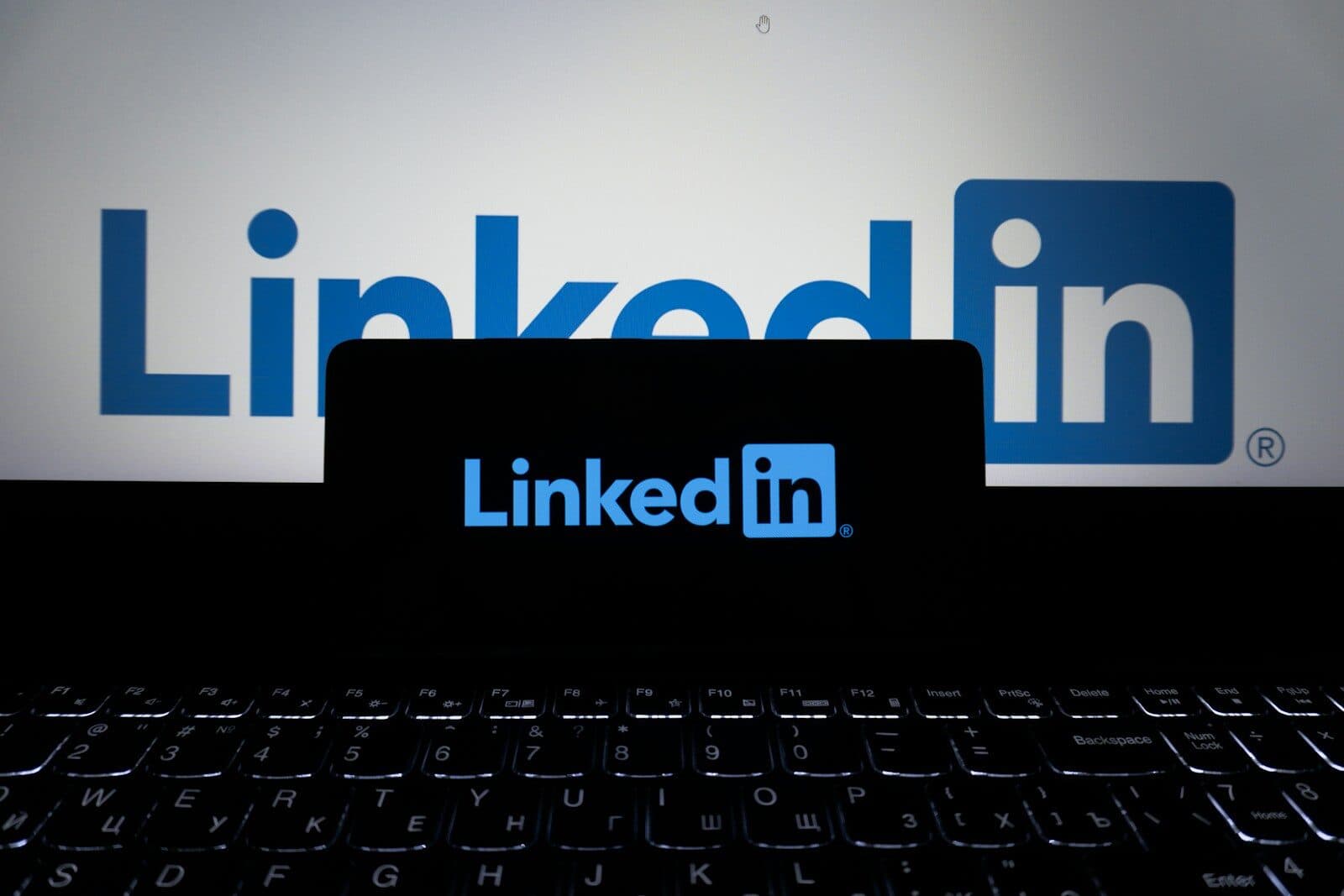 Linkedin logo displayed on a phone and laptop
